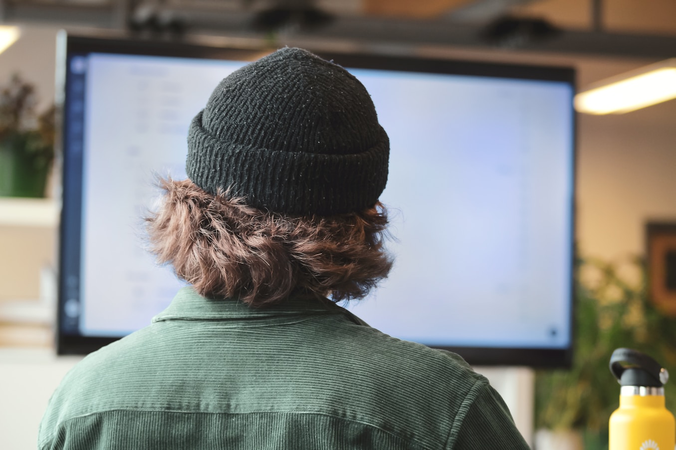 A learner reviewing training content at a large screen